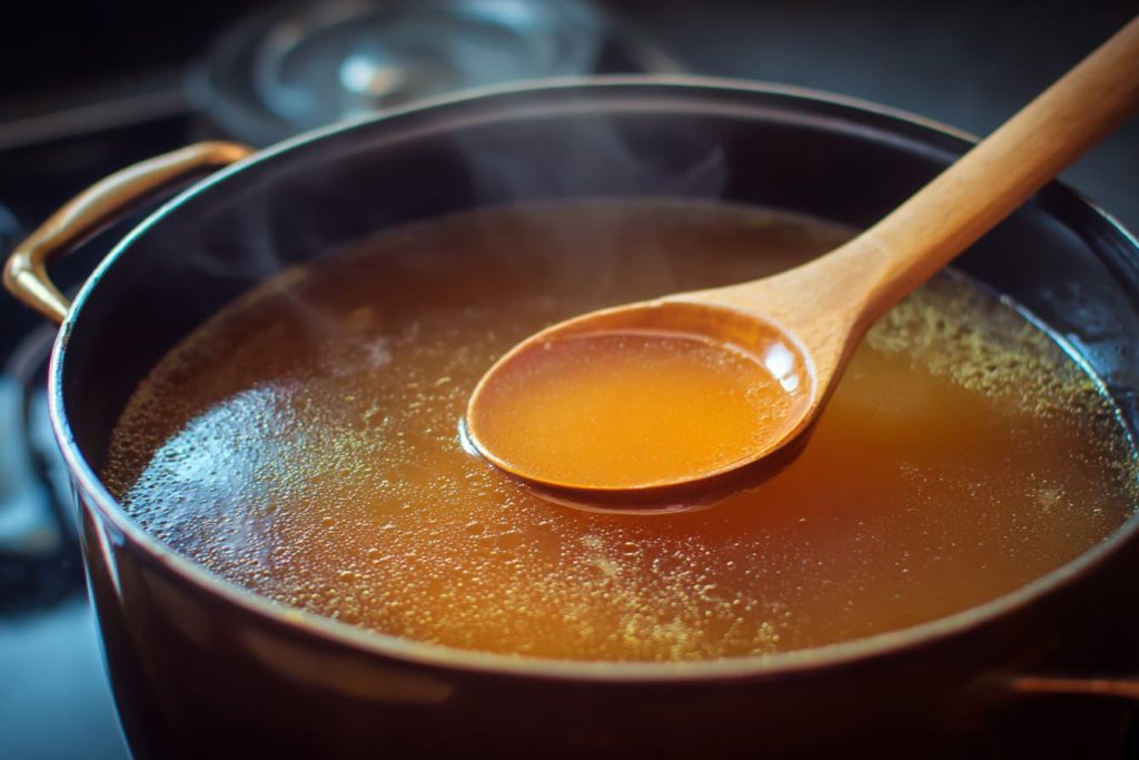 Homemade bone broth simmering slowly, showing a traditional method for making bone broth at home.