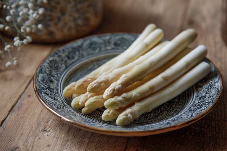 why urine smells after eating asparagus - white asparagus on a plate healthy meal spring vegetable